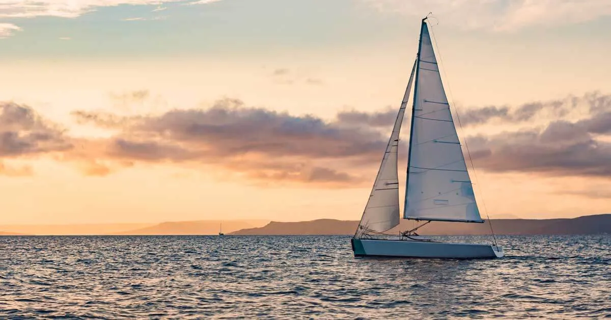 Jachta plující po moři při západu slunce